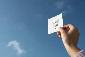 Hand holding a thank you card, representing thoughtful appreciation gifts for employees and meaningful workplace recognition.